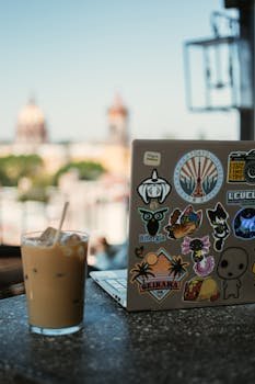 Relaxing with iced coffee on a balcony in San Miguel de Allende, Mexico with a laptop covered in stickers.